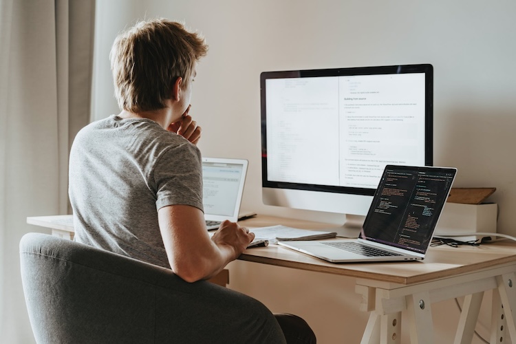 man sitting in front of computers