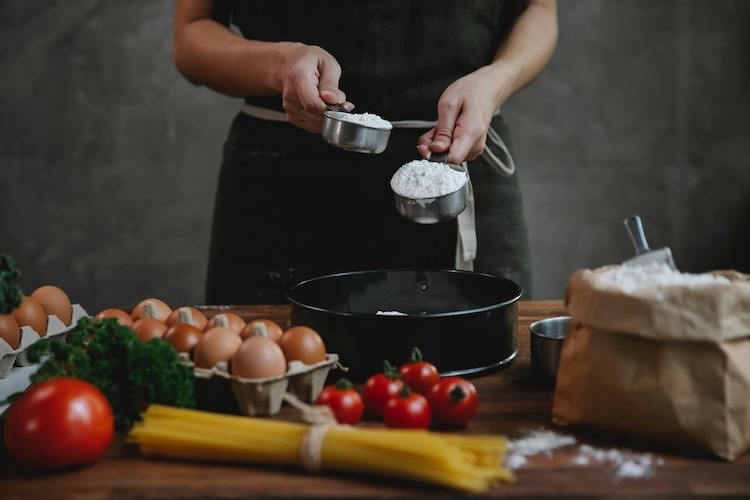 person measuring flour to make pasta