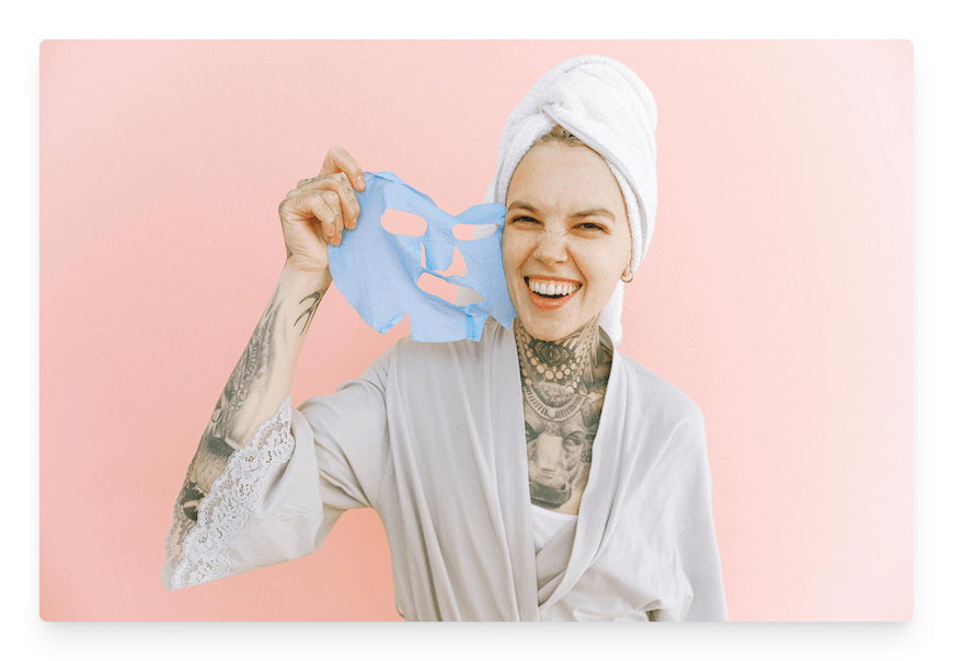 woman taking off sheet face mask