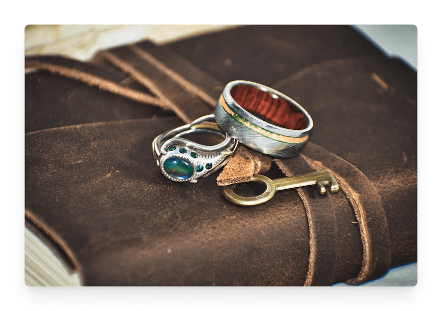 two silver rings with gold key on fabric